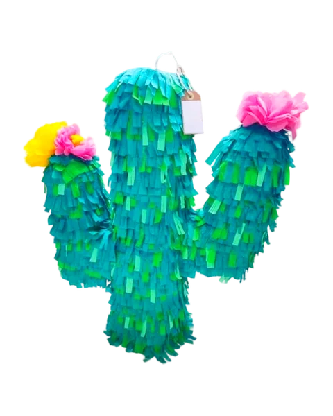 Piñata en forma de cactus de flecos verdes y turquesa, con una flor amarilla y rosa en un brazo y una flor rosa en el otro, recortada sobre fondo liso.